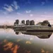 Boats docked at a marina with city skyline reflecting on calm water