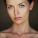 Close-up portrait of a woman with blue eyes against a dark background
