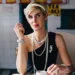 Woman with short blonde hair sitting in a café holding a cigarette