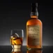 Balvenie whisky bottle with a glass of whisky on a dark background