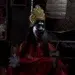 Performer in Kali costume with gold crown, face paint, holding an ID card