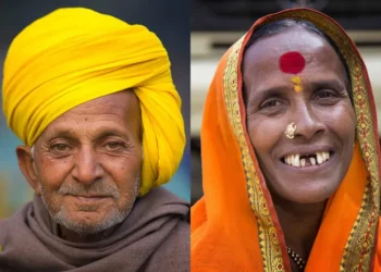 Portraits of an Indian man in yellow turban and woman in orange sari at Ganga Sagar fair