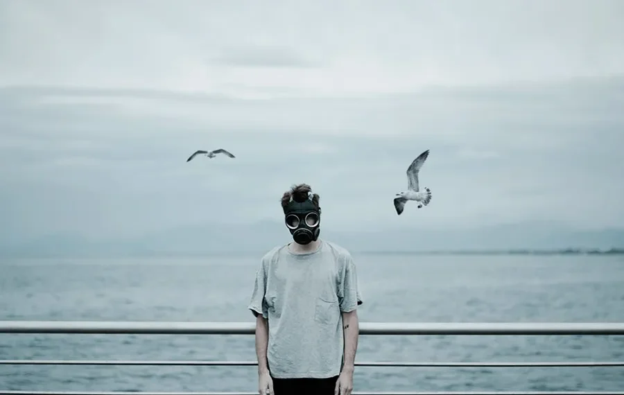 Calling His Life A Messy Heap Of Shades - Paolo Barretta Shoots Gems 26 Man in a gas mask standing by the sea with seagulls, fine art photography