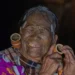 Elderly tattooed Chin tribal woman with large ear gauges smiling, Myanmar