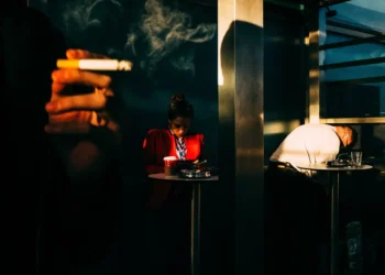 Smoky street scene with two strangers in dramatic light and shadow