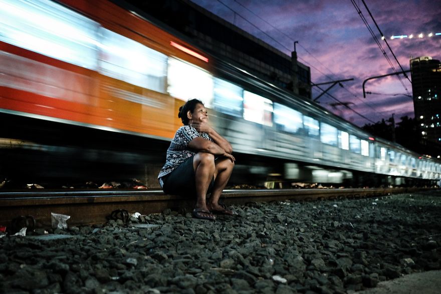 Women Is Sitting Comfortably On The Railway Tracks While Train Is Passing By Just A Couple Of Meters Behind Her
