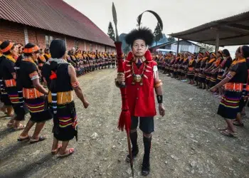 Konyak tribal elder in red coat leading Aoling festival ceremony, Nagaland