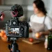 SLR camera on tripod filming woman cooking in kitchen