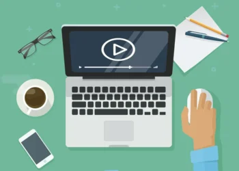 Flat design illustration of a laptop playing video, surrounded by office items