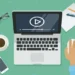 Flat design illustration of a laptop playing video, surrounded by office items