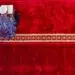 Man reading Quran on red mosque carpet, red color photography
