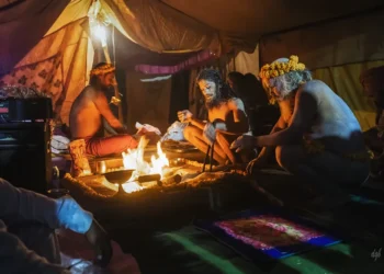 Hindu sadhus performing a sacred fire ritual inside a tent at Kumbh Mela