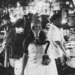 Woman in saree wearing gas mask stands in a busy fish market