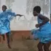 My Personal Best: Swiss Photographer Regula Tschumi 11 Two girls dancing joyfully in blue dresses outside a weathered wall
