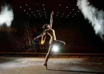 Dancer performing on stage with dramatic lighting and smoke