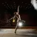 Dancer performing on stage with dramatic lighting and smoke