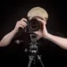 Photographer taking a photo with DSLR camera on tripod against dark background