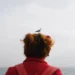 Seagull perched on a woman's hair by the sea, candid street photo