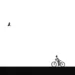 Child on bicycle and soaring bird, minimalist black and white photo