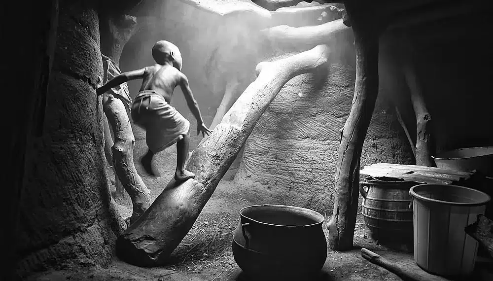 The Daily Life Of African Tribes: Daring & Splendid Photographs By Mario Gerth 35 Child climbing in a rustic hut, african tribes photos in black and white