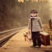 Children portrait photography: boy with teddy bear and suitcase at a railway platform