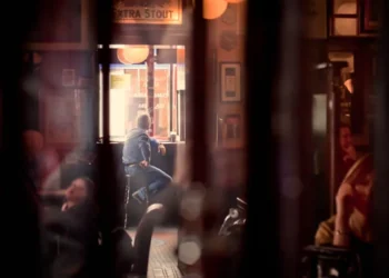 Man sitting alone by a window in a cozy dimly lit interior