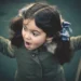 Little girl on a swing with a surprised expression outdoors