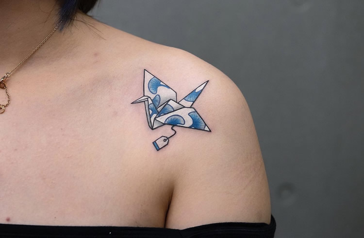 Origami crane tattoo located on the upper arm.