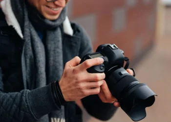 Photographer reviewing photos on a DSLR camera outdoors