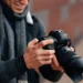 Photographer reviewing photos on a DSLR camera outdoors