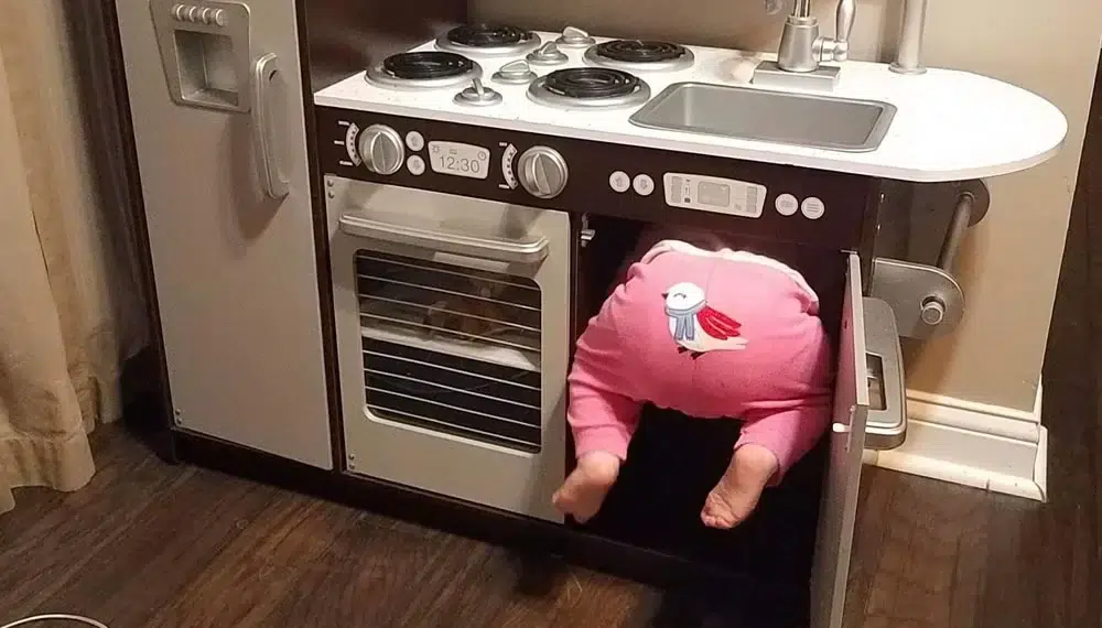 Toddler in pink onesie wedged inside a real kitchen oven funny pictures of kids