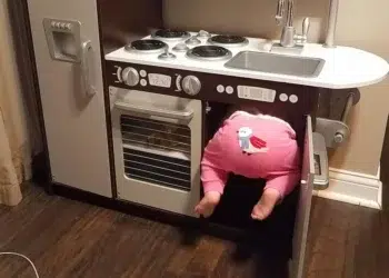 Toddler in pink onesie wedged inside a real kitchen oven funny pictures of kids