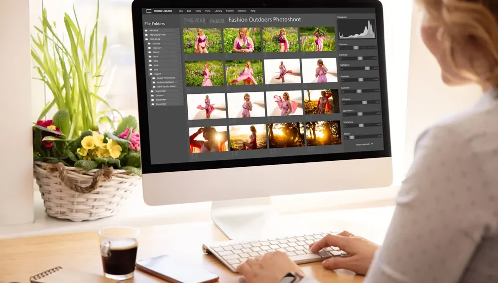 Woman editing fashion photos in photo library software on desktop computer