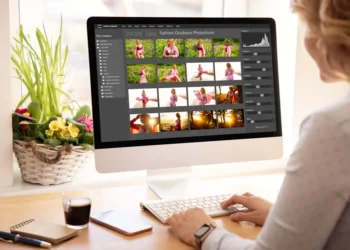 Woman editing fashion photos in photo library software on desktop computer