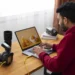 Photographer editing a food photo on a laptop with cameras and lenses nearby