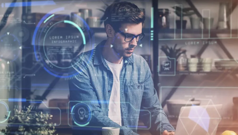 Man with glasses working on a laptop surrounded by glowing AI data visuals