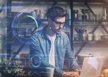 Man with glasses working on a laptop surrounded by glowing AI data visuals