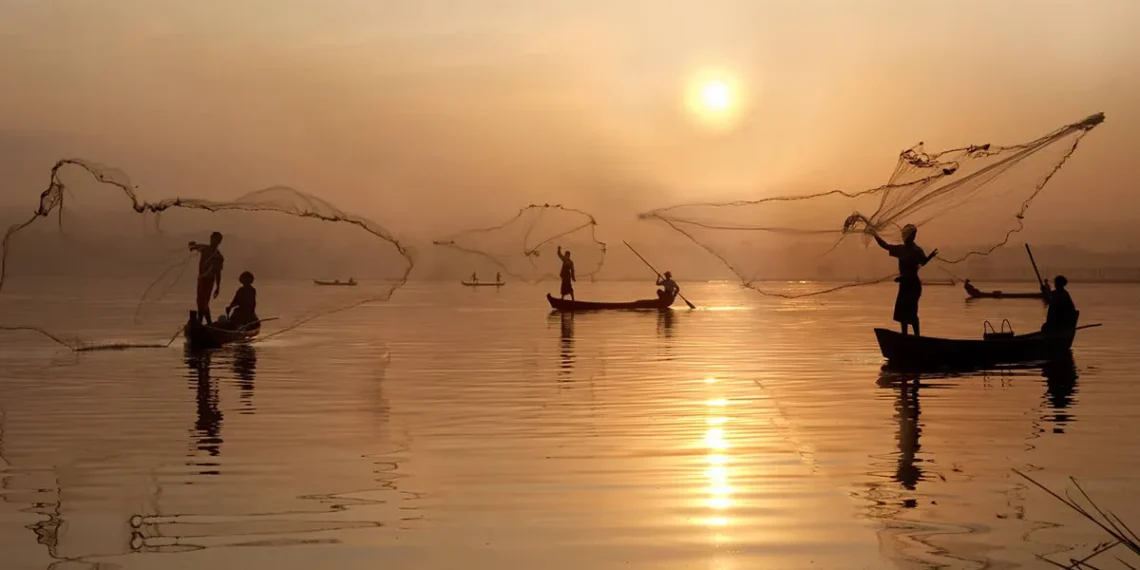 Fishermen casting nets from boats at golden sunrise, countryside life