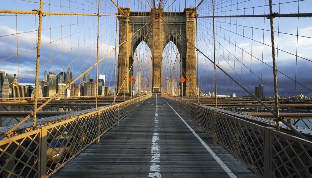 The Best Spots to Capture Stunning Views of the Brooklyn Bridge 4 Symmetrical view of Brooklyn Bridge walkway with NYC skyline in background