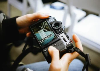 Hands holding a Fujifilm camera showing the Classic Chrome film simulation menu