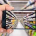 Hand holding a smartphone photographing a supermarket aisle with shelves