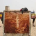 Mastering Juxtaposition in Street Photography: 10 Essential Tips 71 Two camels on a sandy desert, separated by a rusty metal cart