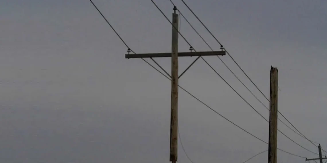 A utility pole suspended mid-air by power lines, never touching the ground