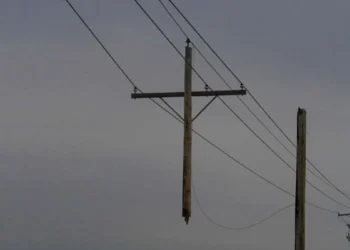 A utility pole suspended mid-air by power lines, never touching the ground