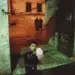 Child holding cotton candy at night near stone gateway, legendary color photography