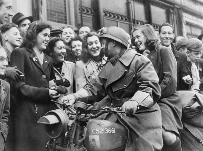 A soldier from the 1st Polish Armoured Division letting a Dutch girl ride on his BSA M20 motorcycle during the liberation of Breda, The Netherlands. October 1944