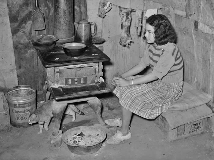 A farmer’s daughter and her cat at the family kitchen in San Antonio, Texas, 1939