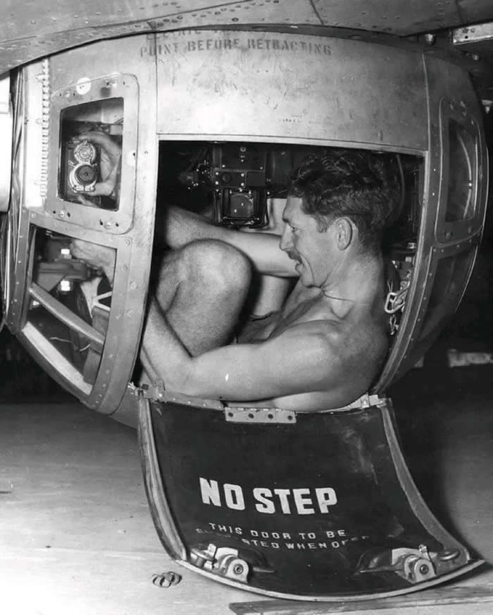 Armorer working on one of the .50 cal Browning machine guns in the ball turret of a B-17 Flying Fortress