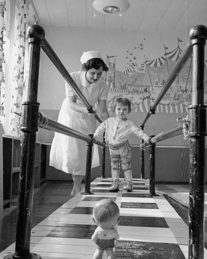 A child with polio learning to walk inside parallel bars (around the time physical therapy was born). Polio Rehabilitation Center Sudbury General Hospital, Canada, 1953.