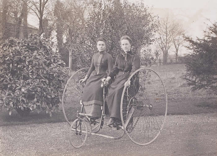Victorian women sharing a trike, 1900s